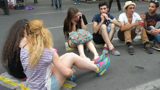 Демонстранты сидят на земле