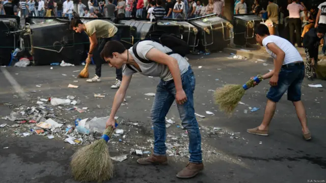 Протестующие подметают мусор