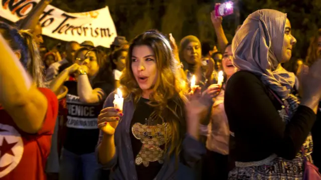 مظاہرین نے دہشت گردی کے خلاف بینر اٹھا رکھے تھے اور کے ہاتھ میں موم بتیاں روشن تھیں