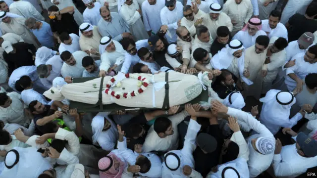 لُفَّت الجثامين بأعلام كويتية، وحملها المشيعون وهو يرددون شعارات دينية