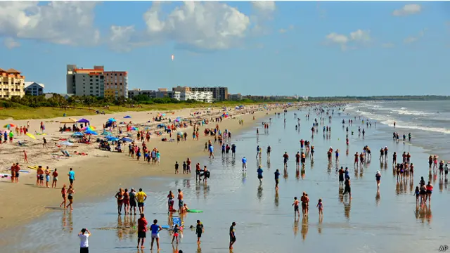 Люди на пляже наблюдают за пуском ракеты