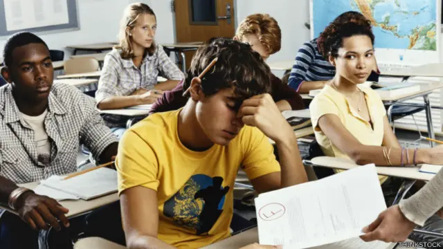 Estudiantes recibiendo exámenes corregidos