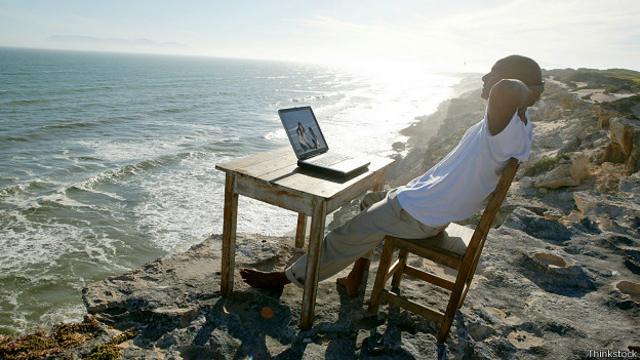 Экспат на морском берегу, с ноутбуком