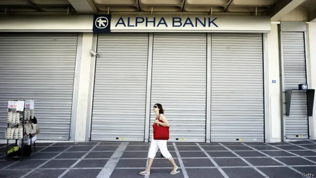 Женщина проходит мимо закрытого банка