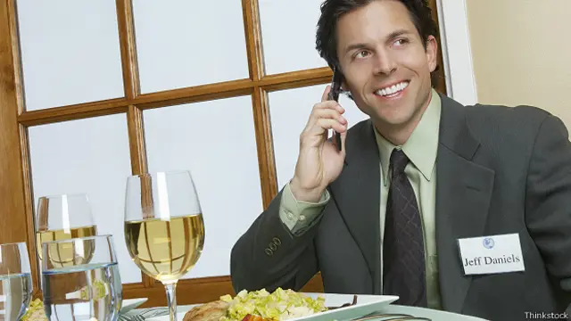 Бизнесмен в ресторане говорит по телефону