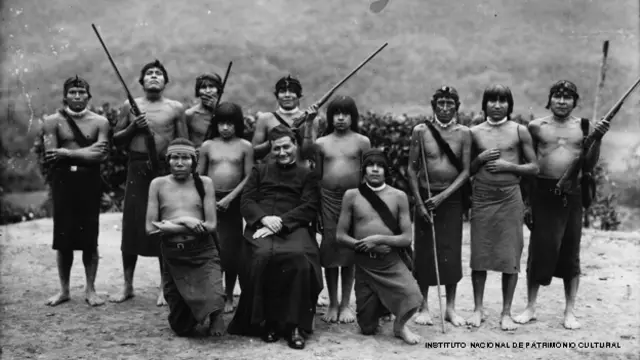 Un sacerdote salesiano posa junto con guerreros shuar,