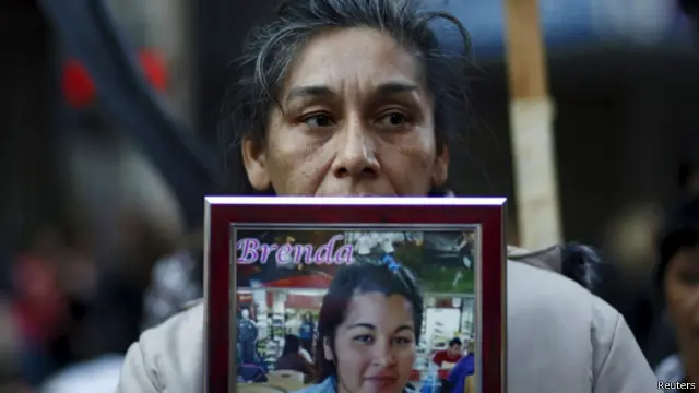 تصویر یکی از قربانیان خشونت علیه زنان که توسط همسرش سوازنده شد، مادر این قربانی با در دست داشتن تصویر او در تجمع سه ژوئن حضور داشت