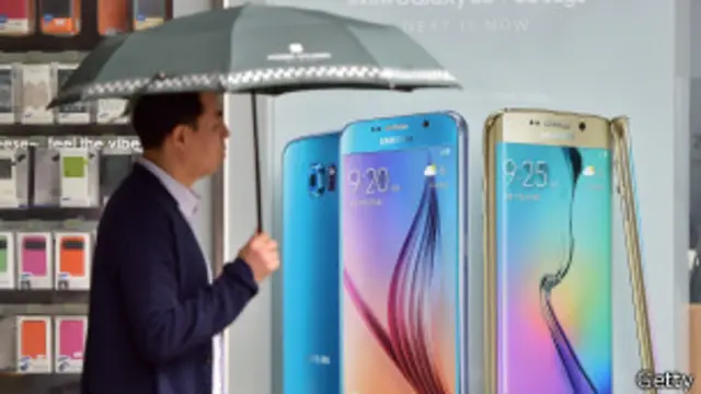 Hombre con paraguas frente a aviso de Samsung