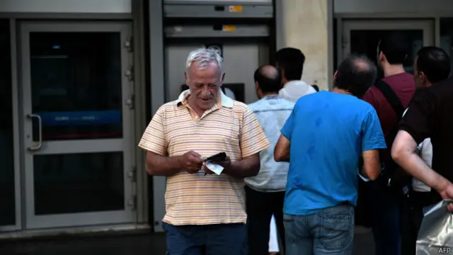 Un señor termina de usar un cajero automático