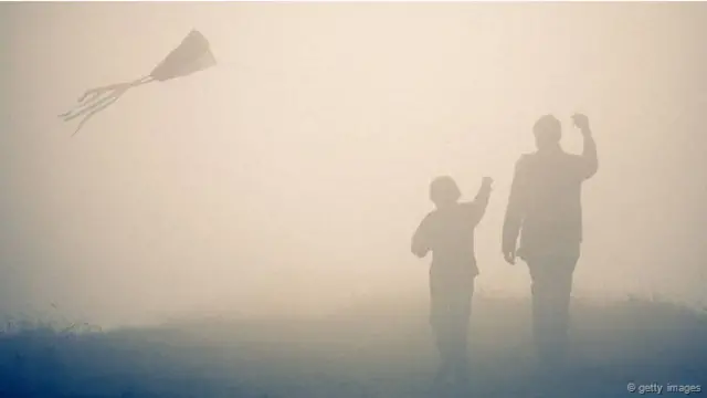 Un hombre y un niño vuelan una cometa