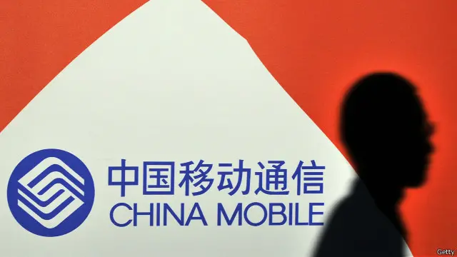 行人在中国移动标志前走过(资料图片)