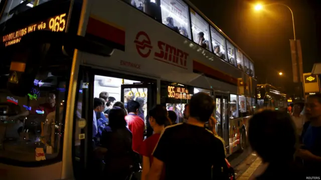 新加坡地铁某车站外受故障影响的乘客设法登上巴士（7/7/2015）