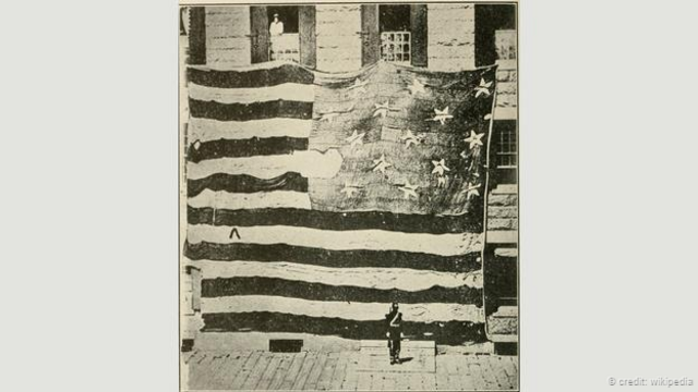 1814年，弗朗西斯•斯科特•凯伊亲眼目睹的，在英军的狂轰滥炸之下，麦克亨利要塞上空依旧迎风飘扬的美国国旗（图片来源：Wikipedia）