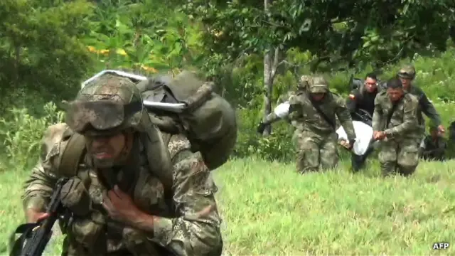 Militares llevan el cuerpo de un guerrillero abatido en junio
