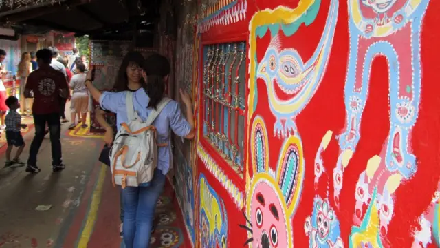 游客在台中彩虹眷村内拍照