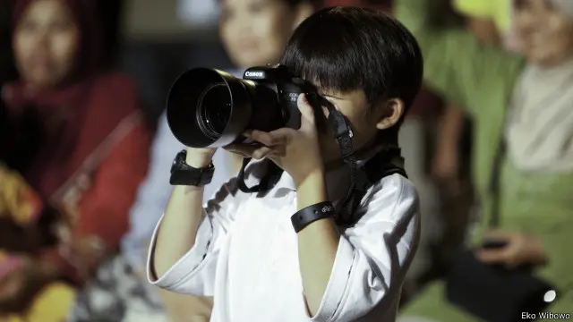 Lebih besar kamera dari pada kepala, kata Eko mengomentari hobi fotografi anaknya. "Saya kenalin kamera dengan lensa tele waktu itu."
