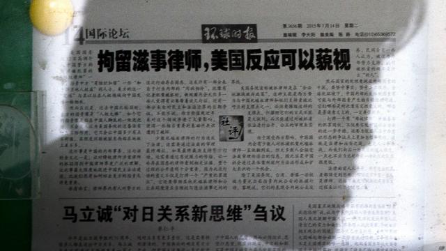 北京某阅报栏前一名路人阅读《环球时报》社论（14/7/2015）