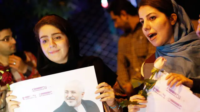 لوگوں کی بڑی تعداد نے جہاں ایرانی پرچم اٹھا رکھے تھے وہیں ایرانی وزیر خارجہ جواد ظریف کی تصاویر بھی۔ 