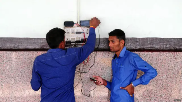 Hombres recargando sus celulares