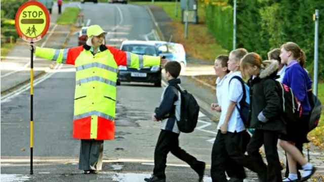 每天上学、放学时分，“棒棒糖大妈”们就准时出现在马路边。孩子们过马路时，大妈们把“棒棒糖”标志牌一横，示意路上的汽车停下来，让孩子们安全、从容的过马路。