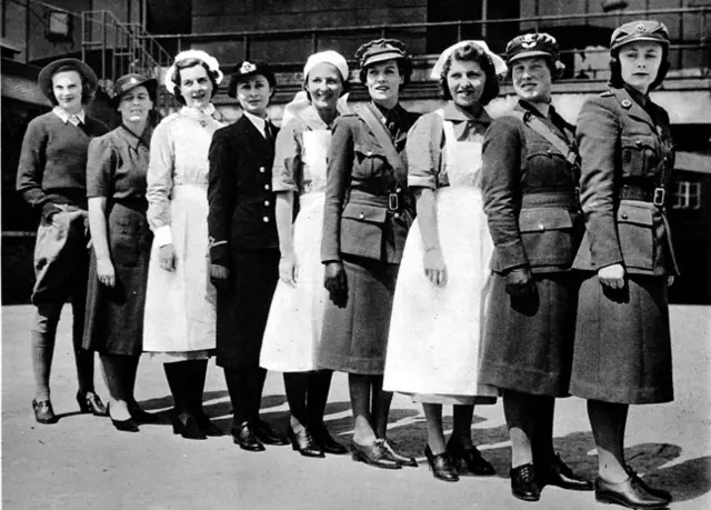 一排哈罗德百货的女员工，每个人穿着不同工种的制服。