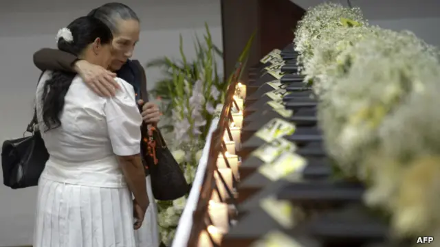 Mujeres frente a féretros con los restos de víctimas del conflicto