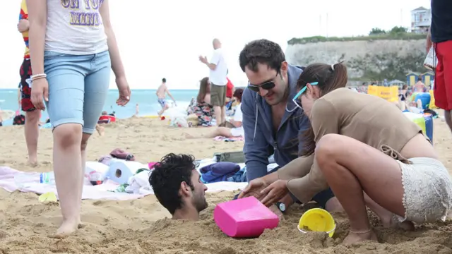 Çimərlikləri yerli sakinlərlə yanaşı xeyli turist də ziyarət edir. Bu qrup, yoldaşlarından birini quma basdırmaqla əylənir.