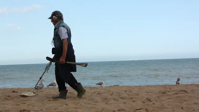 İnsanların çimərliyi tərk etməsinin ardından əllərində metal detektor gəzdirən şəxslər qumluqların arasından dəmir pul axtarırlar.