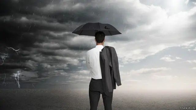 Мужчина под зонтом и молнии на горизонте