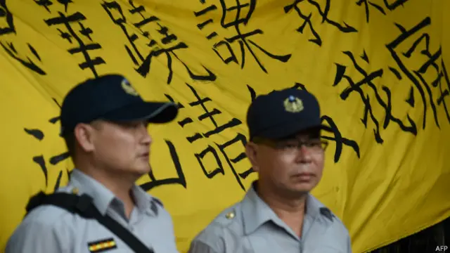 维持秩序的警方站在写着学生诉求的黄布条前。