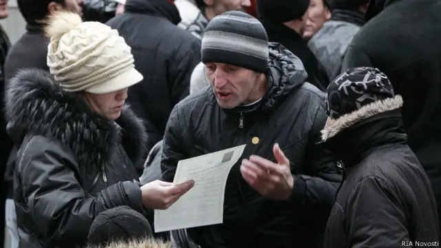 Гастарбайтеры стоят в очереди у консульского отдела посольства Таджикистана, чтобы получить документы для въезда на родину