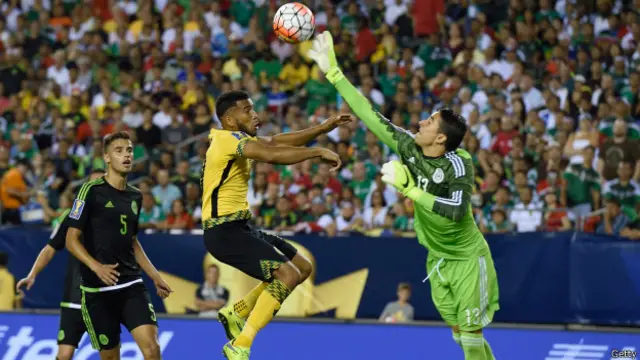 El portero mexicano se interpone entre el jugador jamaiquino y la portería