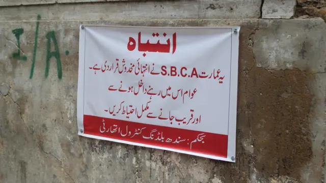 عمارت کے مرکزی دروازے کے ساتھ دیوار پر سرکاری حکام نے نوٹس چسپاں کرکے لوگوں کو اس میں داخل ہونے، رہنے اور قریب جانے سے منع کیا گیا ہے۔