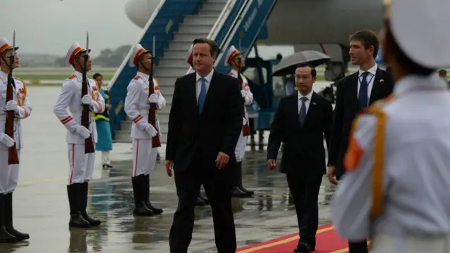 Thủ tướng Anh David Cameron tại sân bay ở Hà Nội. Đằng sau ông là Đại sứ Việt Nam tại Anh, và Đại sứ Anh tại Việt Nam.