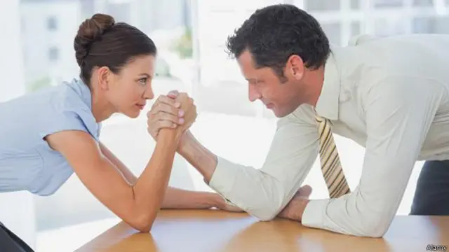 Dos personas haciendo una pulseada en el trabajo