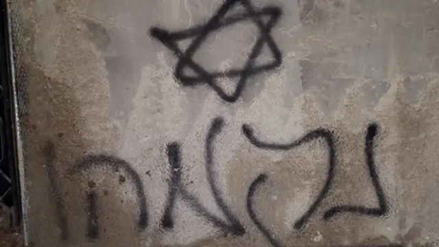 Kundaklanan evin yakınlarında bir duvara İbranice 'İntikam' yazılmış.
