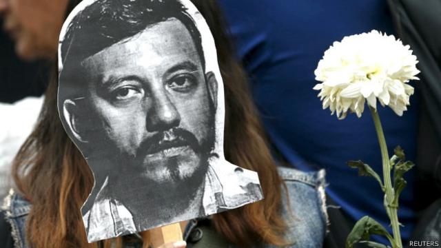 Manifestante en México con una máscara que muestra el rostro del periodista asesinado Rubén Espinosa