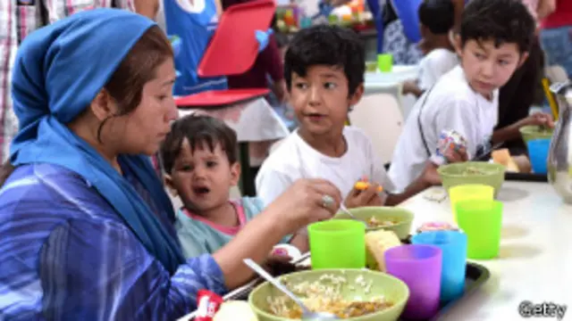Inmigrantes comen en un albergue de Cáritas