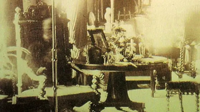 Foto ini dianggap sebagai penampakan hantu Lord Combermere, namun pakar menyakini bahwa sosok serupa hantu itu adalah hasil dari pencahayaan panjang (long exposure), di mana ada seseorang yang sempat duduk di bangku cukup lama sehingga menciptakan bayangan dalam foto. (Kredit: Synbell Corbett)