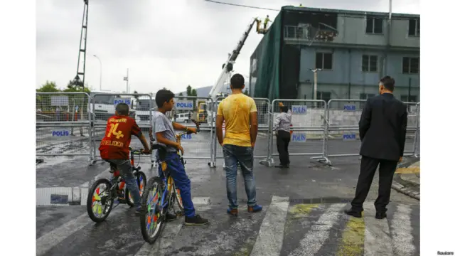 بعض الأشخاص ينظرون إلى مركز الشرطة الذي تضرر بشدة بسبب التفجير في اسطنبول