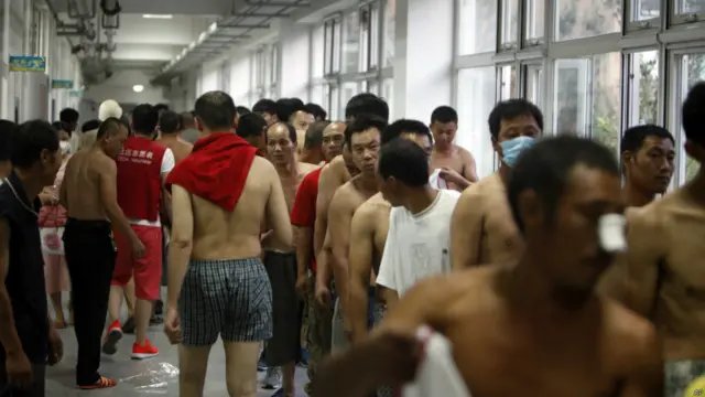 Những người bỏ nhà cửa xếp hàng đợi nhận quần áo được quyên góp