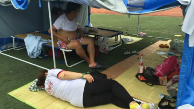 受爆炸影響的災民在臨時安置點中休息