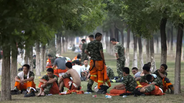 天津爆炸现场附近一批消防员在树底下休息（15/8/2015）