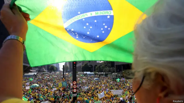 Un manifestante sostiene la bandera de Brasil durante una protesta callejera contra el gobierno.