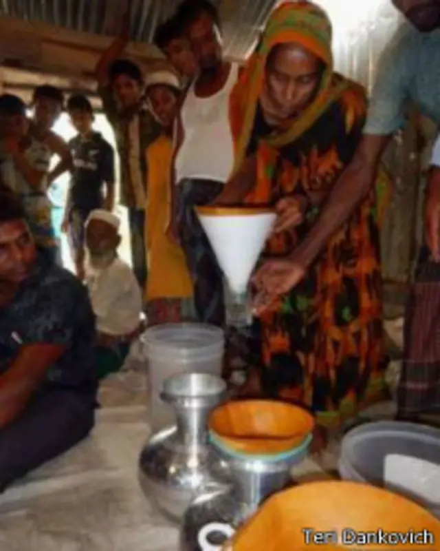 Seorang perempuan mempraktikkan penyaringan air menggunakan halaman dari buku