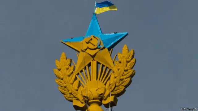 Рабочий моет перекрашенную звезду на Котельнической набережной