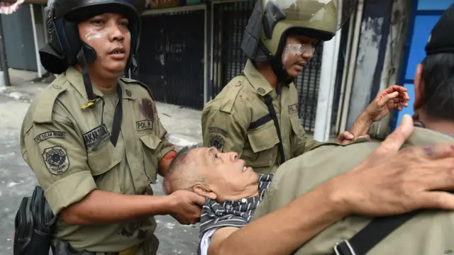 Petugas keamanan mengevakuasi korban saat terjadi penghancuran perkampungan kumuh di pinggir sungai di Kampung Pulo, Jakarta, 20 Agustus 2015. 