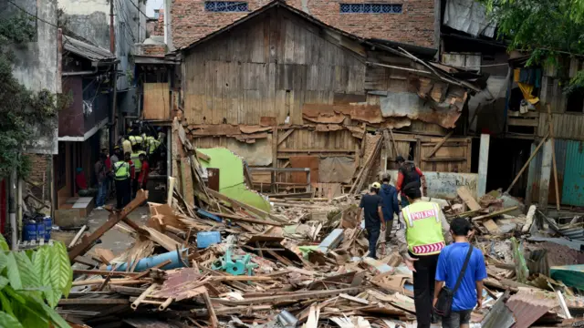 Polisi memeriksa kawasan hunian pinggir sungai yang sebagian sudah dihancurkan di Kampung Pulo, Jakarta, pada 20 Agustus 2015. 
