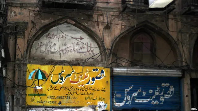 جگمگ جگمگ کرتے کھوکھوں اور پینا فلیکس کے بیچوں بیچ کہیں کہیں لال اینٹوں سے بنی کوئی محراب والی بوڑھی دکان نظر آ جاتی تھی