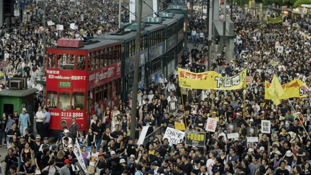 香港金钟道上多辆电车因游行人士而停下（1/7/2003）